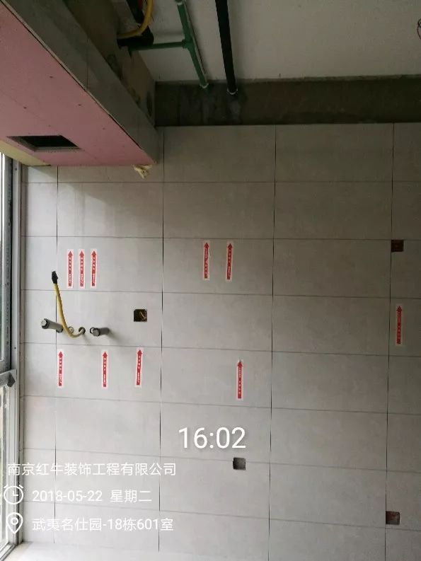 南京武夷名仕園124平米簡美風(fēng)格裝修  享受家?guī)淼臏囟?0五月份_墻磚鋪貼完成后，紅牛裝飾的工人會用專用護(hù)角條對瓷磚角保護(hù)，用標(biāo)貼標(biāo)出水管、線管走向示意。